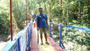 Seorang warga penyandang disabilitas sedang menyeberangi jembatan yang dibangun oleh Sasaka untuk sebagai fasilitas publik desa